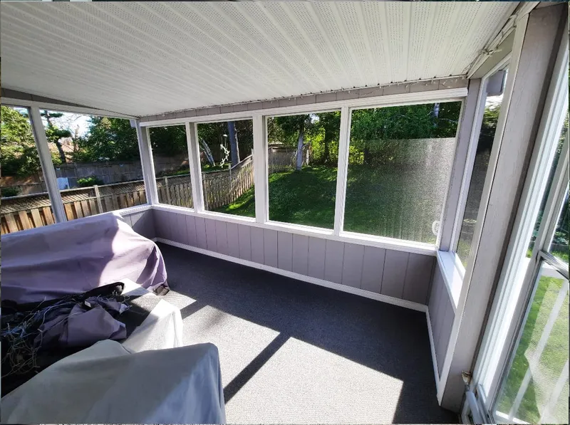 The same porch from a slightly different angle, showing the covered furniture and yard beyond.