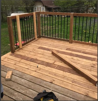A newly framed deck corner with railing posts installed.